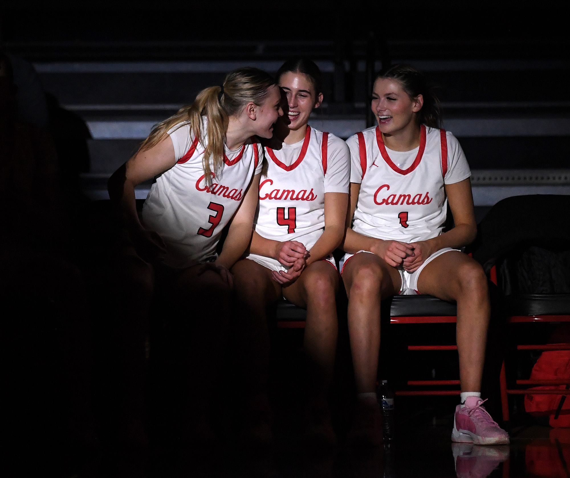 Camas senior Riley Sanz, from left, talks to junior Sophie Buzzard and senior Reagan Jamison during pregame introductions Friday, Dec. 15, 2023, before the Papermakers’ 58-46 win against Eastlake at Camas High School.