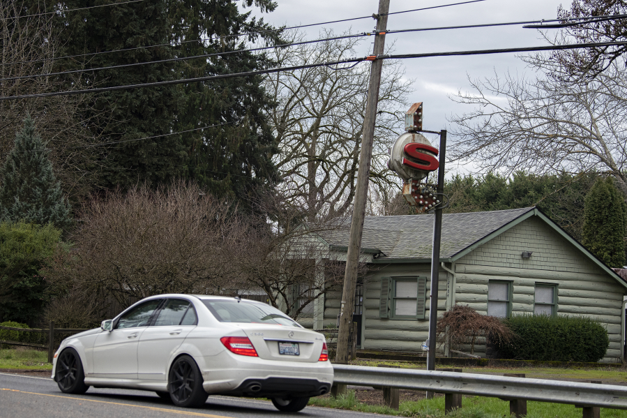 A motorist passes the sign for the former Sigrid&rsquo;s cafe, which operated for many years along Northeast 72nd Avenue north of Vancouver. The log cabin that housed the restaurant is now a private residence.