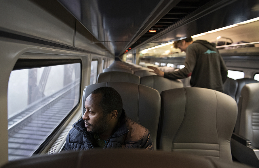 Passenger Peter Ngugi of Tacoma checks out the view while riding the stretch from the Vancouver train station toward Portland on Wednesday morning. Amtrak Cascades added two new round trips between Portland and Seattle last week.