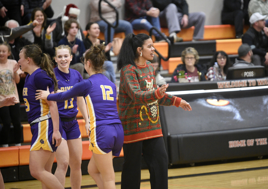 Columbia River coach Tuileisu Anderson greets her players as they come off the court at the end of the first half of River&rsquo;s 68-47 win over Washougal at Washougal High School on Thursday, Dec. 21, 2023.
