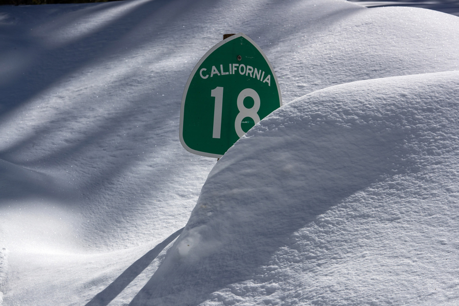 A sign for Highway 18 in the San Bernardino Mountains is nearly obscured by snow on March 3.