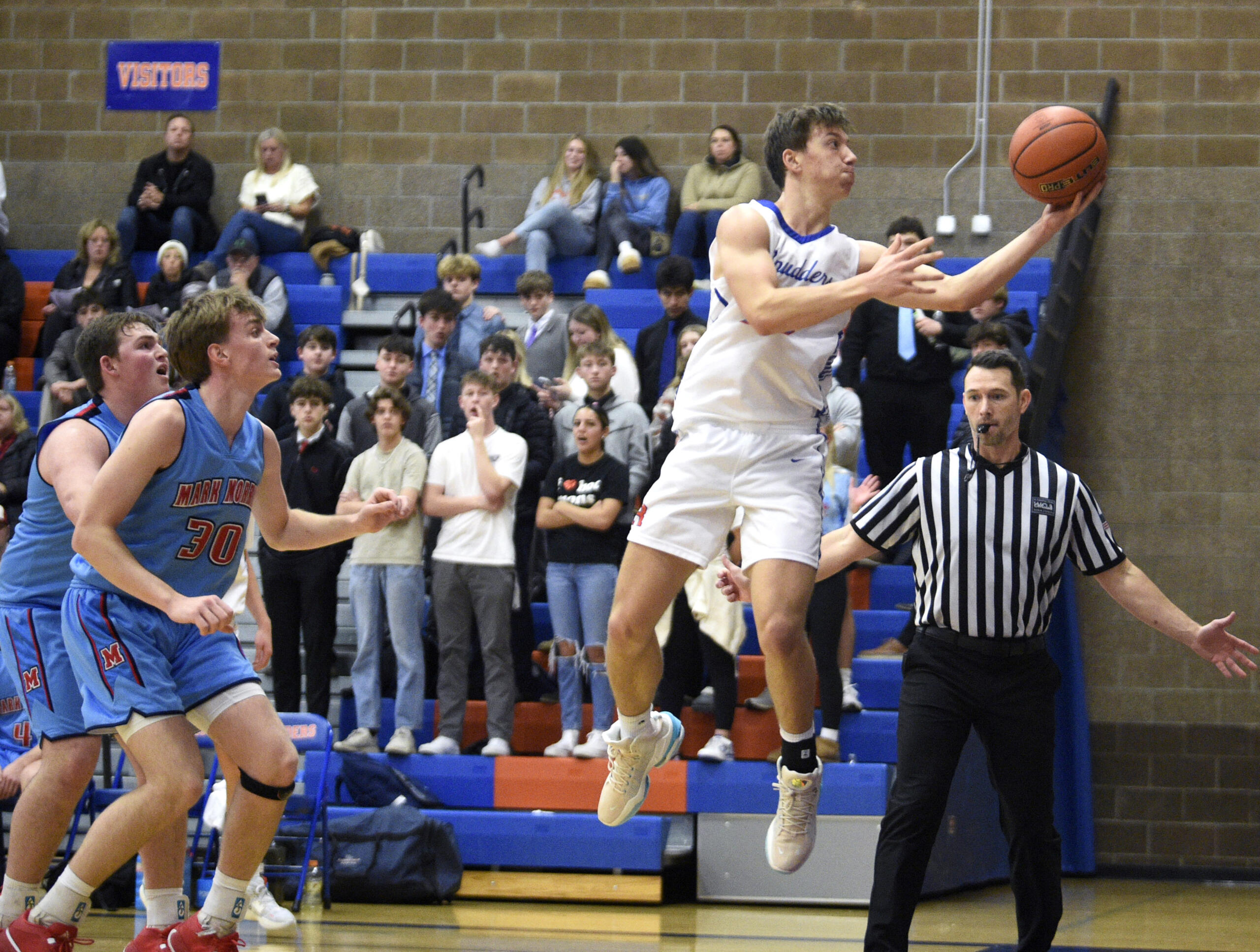 Ridgefield’s Jack Hughes leaps to save a ball from going out of bounds in a 2A Greater St. Helens League boys basketball game against Mark Morris on Thursday, Dec. 7, 2023, at Ridgefield High School.