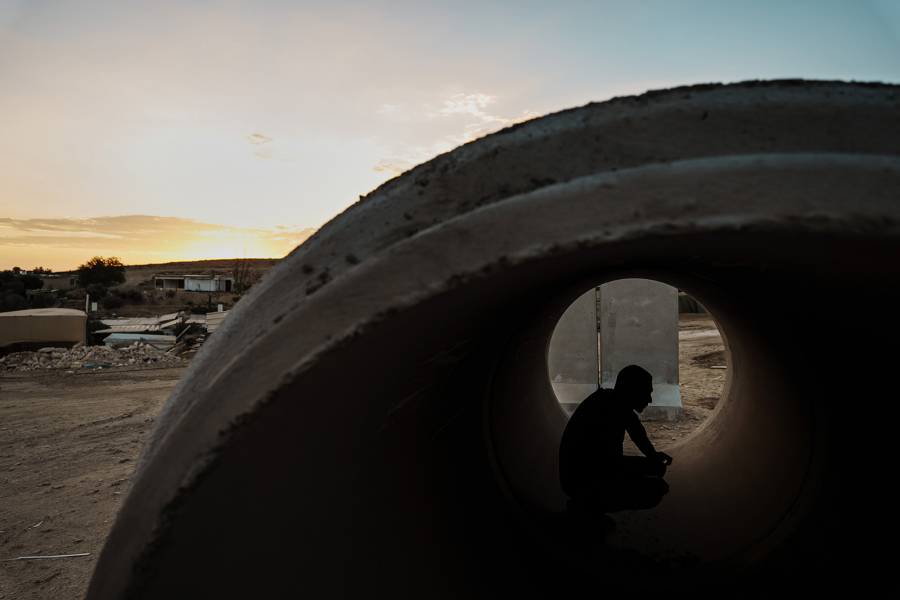Mohammad Qeeran uses a concrete pipe as a makeshift bomb shelter in the Bedouin village of Sawa.