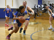 Ridgefield’s Jalise Chatman spins and drives toward the basket during a non-league girls basketball game against La Center on Monday, Dec. 18, 2023, at La Center High School.
