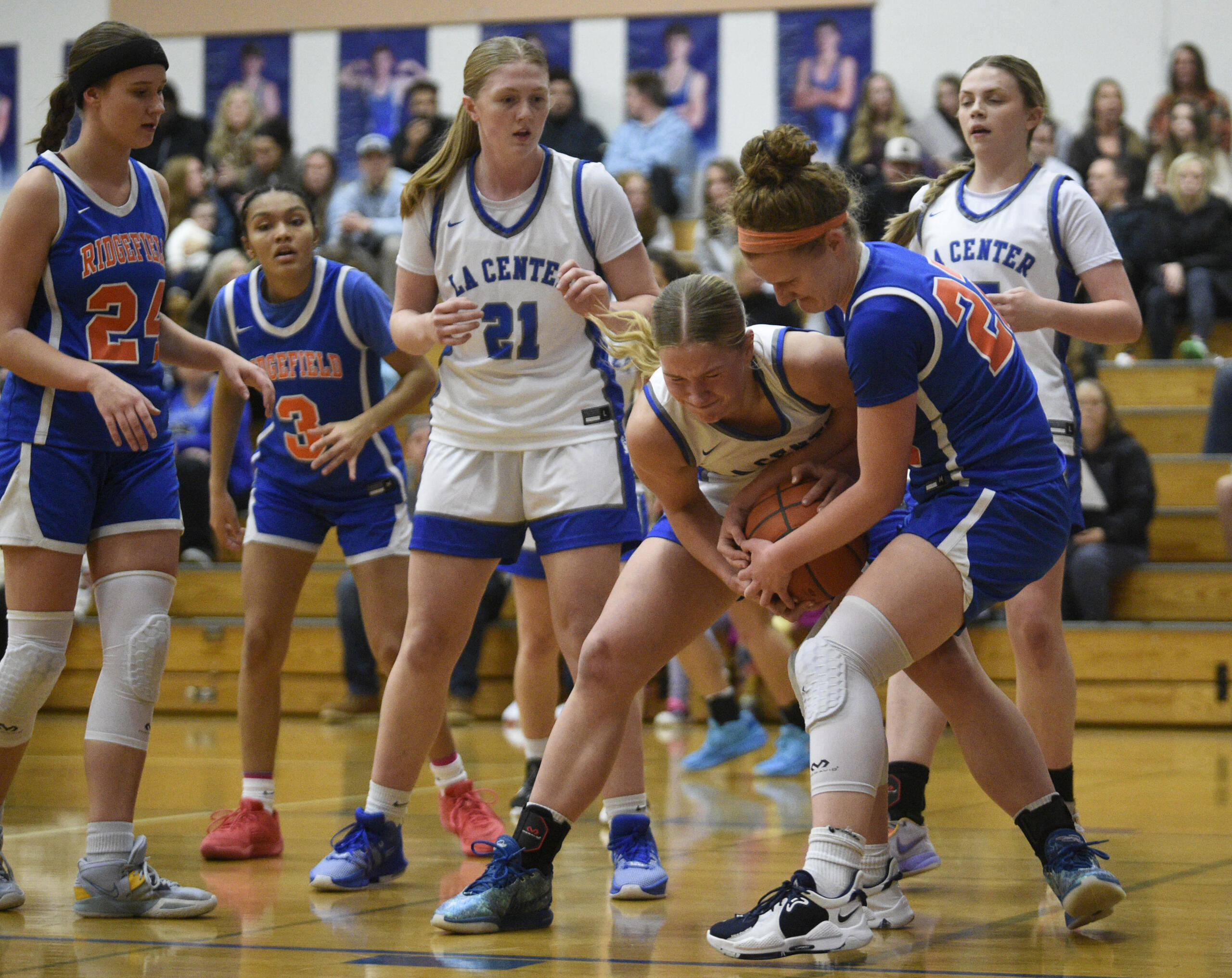 La Center’s Mekenzie Schockelt and Ridgefield’s Elizabeth Swift get tied up for a jump ball call during a non-league girls basketball game on Monday, Dec. 18, 2023, at La Center High School.