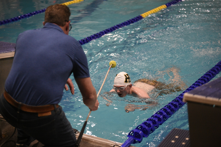 Don Johnson, left, prepares to tap his son Charles Johnson during the 200 yard individual medley race at Kelso High School on Wednesday, Dec. 20, 2023. Charles Johnson is a student at the Washington State School for the Blind who swims competitively for Hudson&#039;s Bay High School.