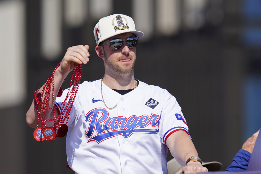 Texas Rangers&#039; Mitch Garver tosses beaded necklaces during a World Series baseball championship parade, Friday, Nov. 3, 2023, in Arlington, Texas. The parade comes two days after the Rangers wrapped up the World Series with a 5-0 win on the road against the Arizona Diamondbacks.