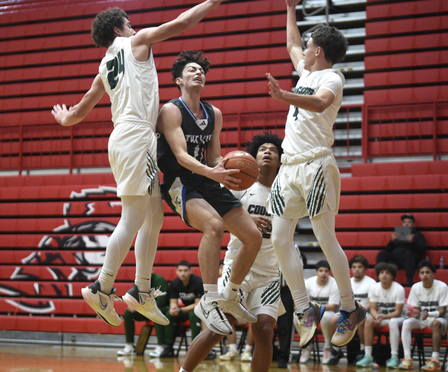 Mountain View&iacute;s Daniel Dolev, center, goes up with the ball over Weed (Calif.) defenders Logan Bowles (24) and Maddox Mize (4) during a boys basketball game in the Myron Lawrence Memorial Tournament on Wednesday, Dec. 27, 2023, at Fort Vancouver High School.