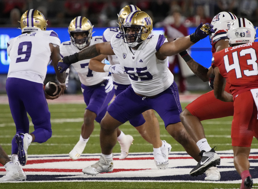 Washington offensive lineman Troy Fautanu (55) blocks for running back Dillon Johnson (7) who takes a handoff from quarterback Michael Penix Jr. (9). Fautanu and the Huskies&#039; offensive line paved the way for No. 2 Washington to make the College Football Playoff. They are scheduled to face No. 3 Texas in the Sugar Bowl, Monday, Jan. 1, 2024.