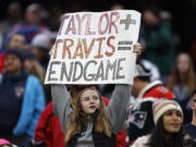 FILE - A fan displays a sign that calls attention to Taylor Swift and Kansas City Chiefs tight end Travis Kelce during the second half of an NFL football game between the Chiefs and the New England Patriots, Sunday, Dec. 17, 2023, in Foxborough, Mass.