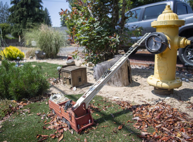 Toy firefighters climb a ladder toward a hydrant in Jermaine Boddie&rsquo;s fantasy yard in Hazel Dell.