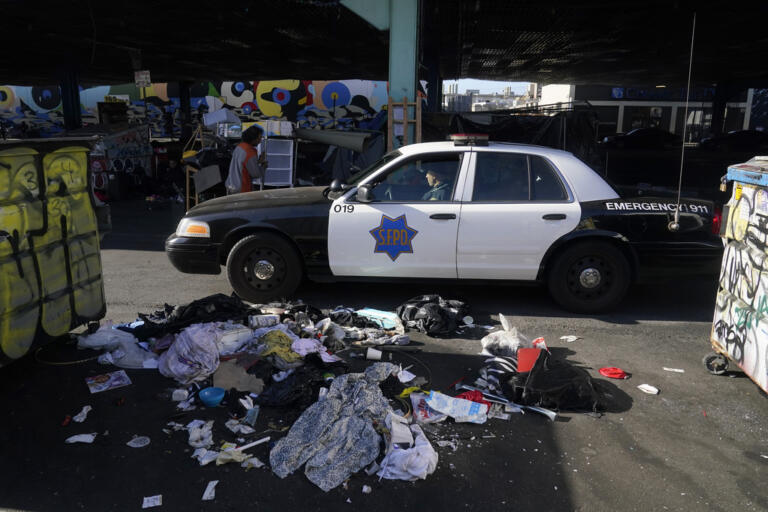 A San Francisco Police Department vehicle drives through a homeless encampment being cleaned up in San Francisco, Tuesday, Aug. 29, 2023. Cities across the U.S. are struggling with and cracking down on tent encampments as the number of homeless people grows, largely due to a lack of affordable housing. Homeless people and their advocates say sweeps are cruel and costly, and there aren't enough homes or beds for everyone.