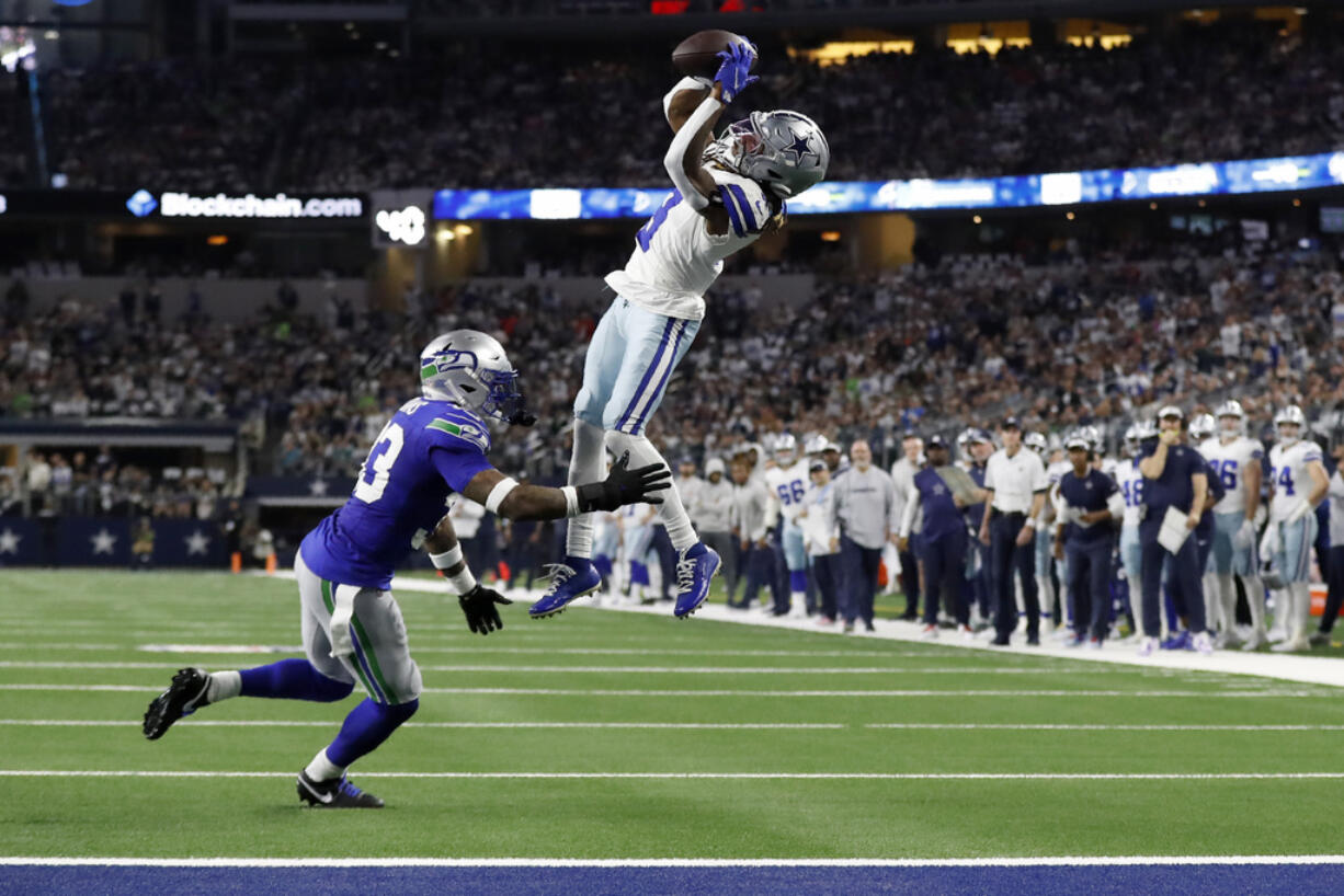 Dallas Cowboys wide receiver Brandin Cooks (3) catches a pass for a first down as Seattle Seahawks safety Jamal Adams (33) defends in the first half of an NFL football game in Arlington, Texas, Thursday, Nov. 30, 2023.