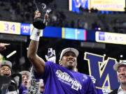 Washington quarterback Michael Penix Jr. celebrates with his MVP trophy after Washington defeated Oregon in the Pac-12 championship NCAA college football game Friday, Dec. 1, 2023, in Las Vegas.