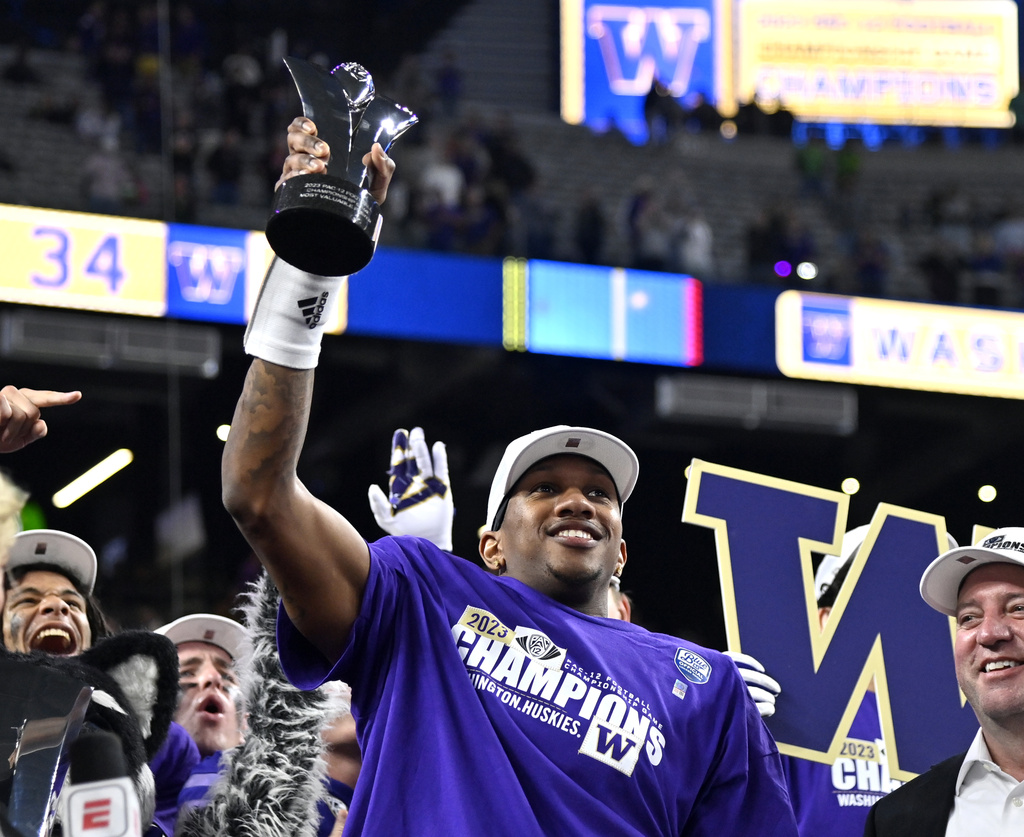 Washington quarterback Michael Penix Jr. celebrates with his MVP trophy after Washington defeated Oregon in the Pac-12 championship NCAA college football game Friday, Dec. 1, 2023, in Las Vegas.