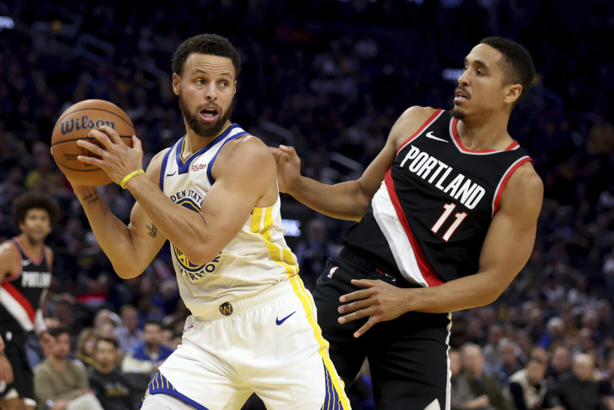 Golden State Warriors guard Stephen Curry grabs a rebound next to Portland Trail Blazers guard Malcolm Brogdon (11) during the first half of an NBA basketball game in San Francisco, Wednesday, Dec. 6, 2023.