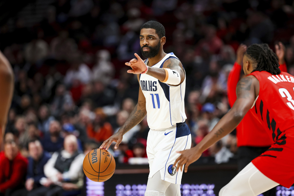 Dallas Mavericks guard Kyrie Irving gestures to teammates during the first half of their NBA basketball game against the Portland Trail Blazers on Friday, Dec. 8, 2023, in Portland, Ore.