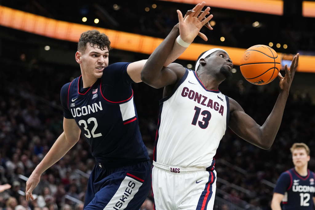 UConn center Donovan Clingan (32) vies for the ball against Gonzaga forward Graham Ike (13) during the second half of an NCAA college basketball game Friday, Dec. 15, 2023, in Seattle.