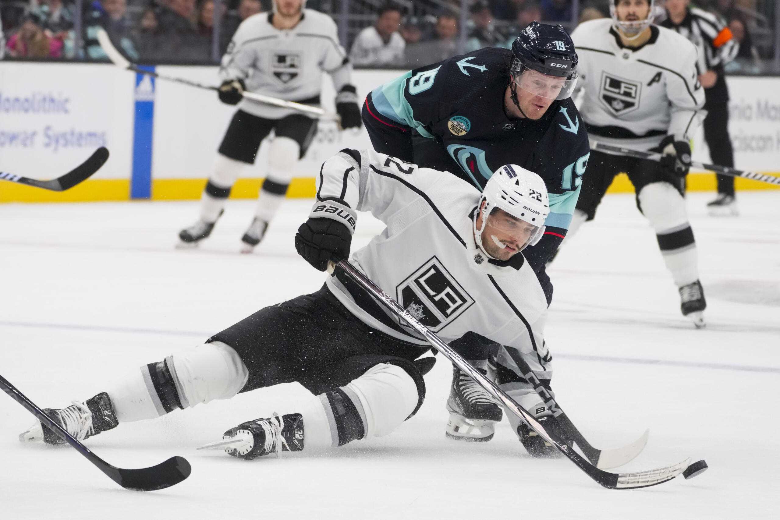 Los Angeles Kings left wing Kevin Fiala (22) tries to keep control of the puck as he falls against Seattle Kraken left wing Jared McCann (19) during the second period of an NHL hockey game Saturday, Dec. 16, 2023, in Seattle.