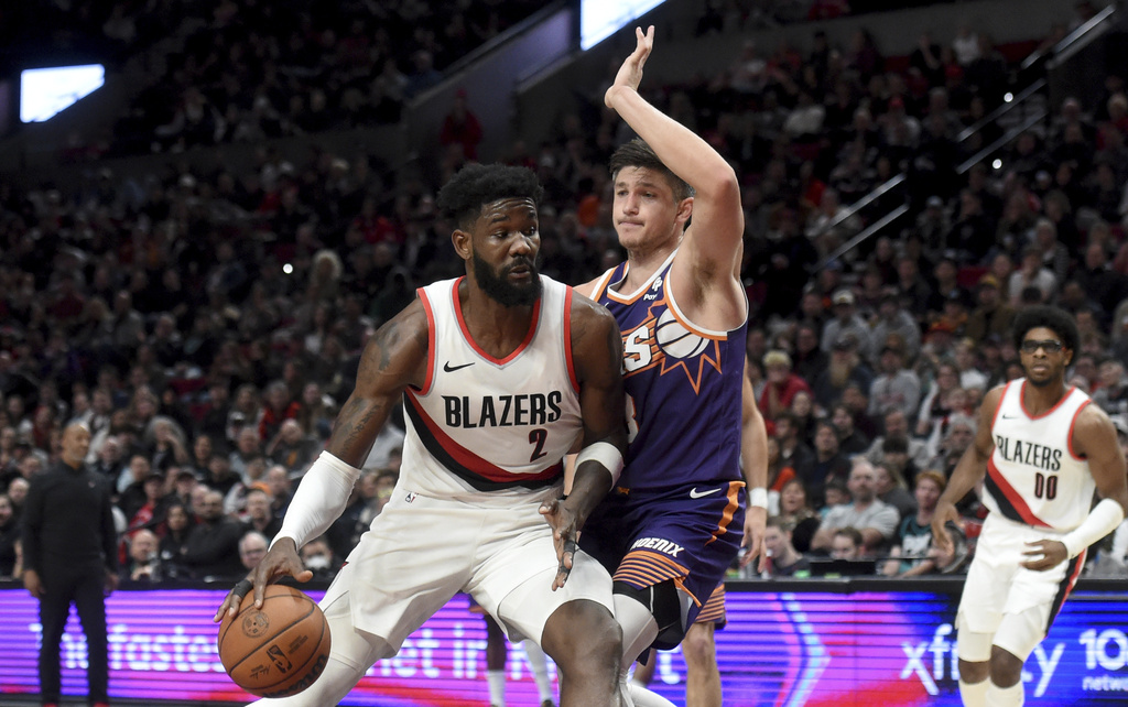 Portland Trail Blazers center Deandre Ayton, left, drives to the basket against Phoenix Suns guard Grayson Allen during the second half of an NBA basketball game in Portland, Ore., Tuesday, Dec. 19, 2023. The Blazers won 109-104.