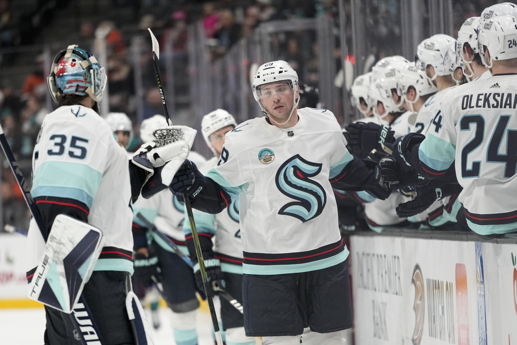 Seattle Kraken defenseman Vince Dunn, center, celebrates with teammates after his goal during the first period of an NHL hockey game against the Anaheim Ducks, Saturday, Dec. 23, 2023, in Anaheim, Calif. (AP Photo/Jae C.