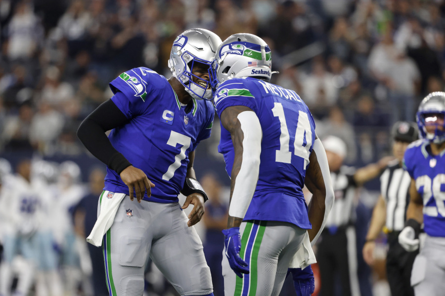 Seattle Seahawks quarterback Geno Smith (7) and wide receiver DK Metcalf (14) celebrate afer Metcalf caught a touchdown pass late in the first half of an NFL football game against the Dallas Cowboys in Arlington, Texas, Thursday, Nov. 30, 2023.