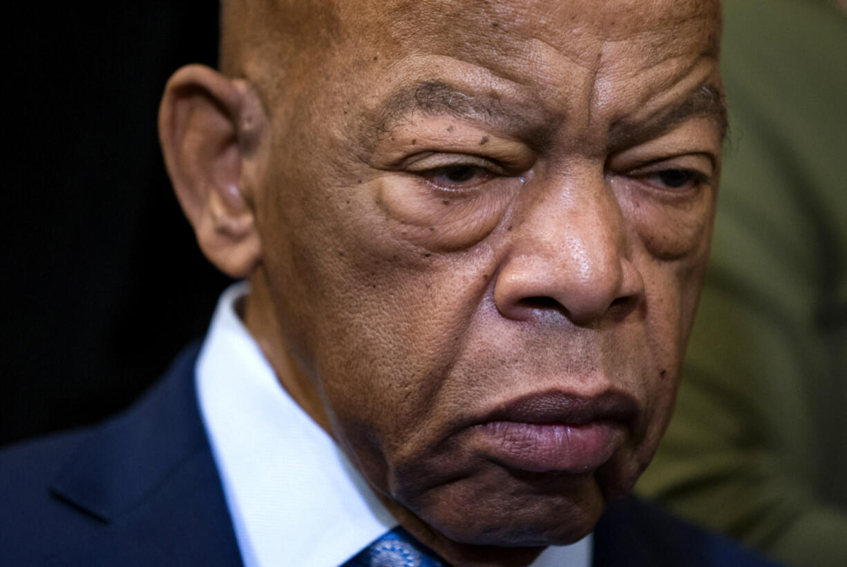 FILE - In this Friday, Dec. 6, 2019, file photo, civil rights leader U.S. Rep. John Lewis, D-Ga., is extolled at an event with fellow Democrats before passing the Voting Rights Advancement Act to eliminate potential state and local voter suppression laws, at the Capitol in Washington.  An upcoming biography of Lewis will draw upon hundreds of interviews, along with the civil rights activist&rsquo;s FBI files and materials from a planned book that was never completed.   (AP Photo/J.