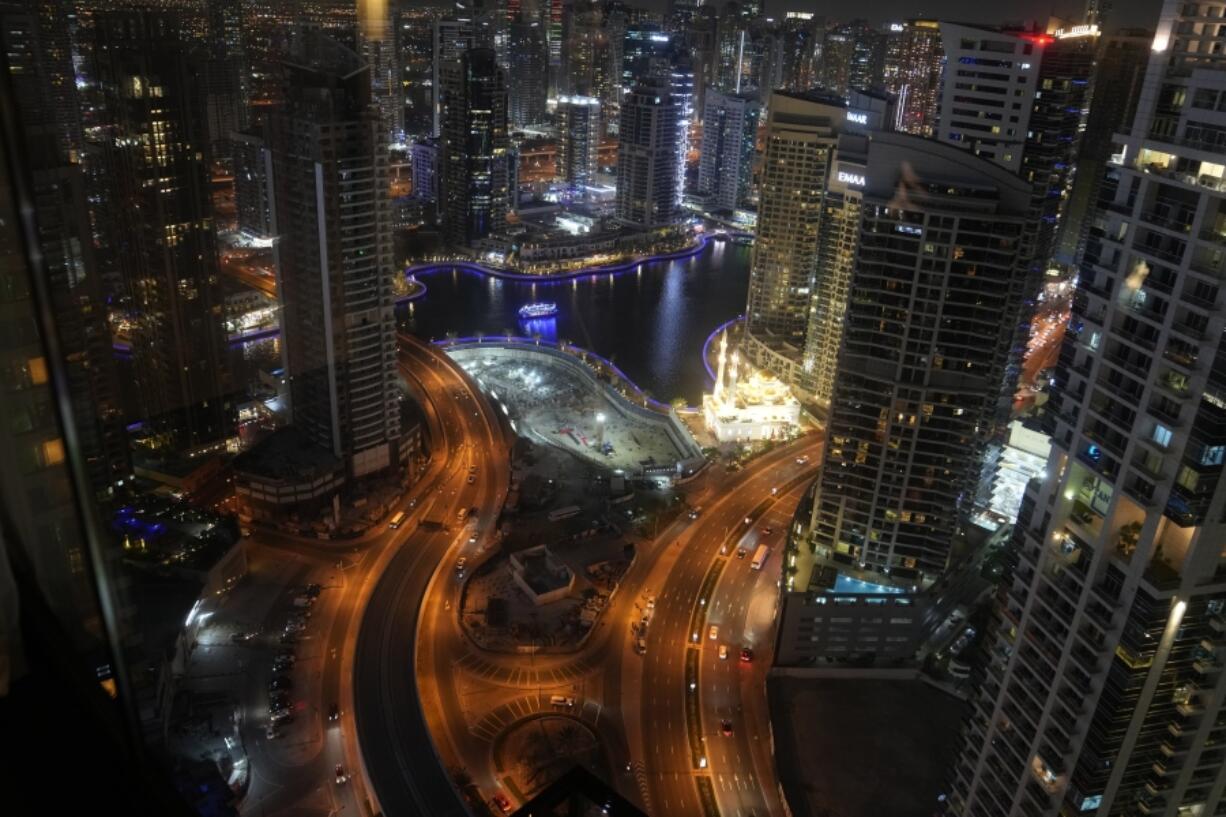 Vehicles move down a road at night as Dubai, United Arab Emirates hosts the COP28 U.N. Climate Summit, Tuesday, Dec. 5, 2023, in Dubai, United Arab Emirates.