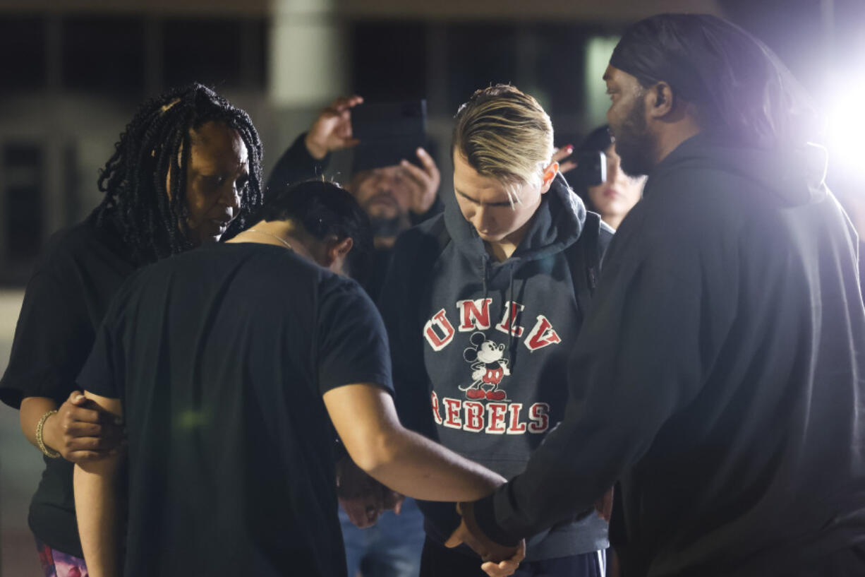 University of Nevada, Las Vegas, student Carlos Casillas, 23, second from right, prays at the Las Vegas Convention Center reunification area where he was transported after a fatal shooting at the campus in Las Vegas, Wednesday, Dec. 6, 2023.