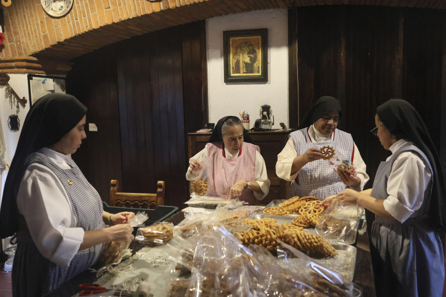 Nuns Alejandra Jaime, 39, from left, Maria Ines Maldonado, 76, Maria Auxiliadora Estrada, 59, and Patricia Marin, 28, store fritters with Christmas figures in clear plastic bags for sale Dec. 7 at the Convent of the Perpetual Adorers of the Most Blessed Sacrament in Mexico City.