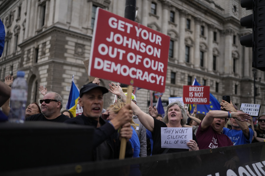 FILE - Anti-Brexit protesters sing to music standing on a traffic island across the street from the Houses of Parliament, in London, Wednesday, June 29, 2022. Britain is one of the world&rsquo;s oldest democracies, but some worry that essential rights and freedoms are under threat. They point to restrictions on protest imposed by the Conservative government that have seen environmental activists jailed for peaceful but disruptive actions.