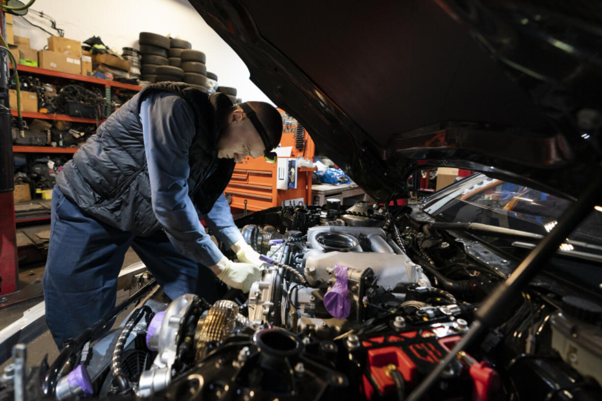 File - Mechanic David Stoliaruk works on the engine of a car at IC Auto in Philadelphia, May 2, 2023. On Friday, the U.S. government issues its November jobs report.