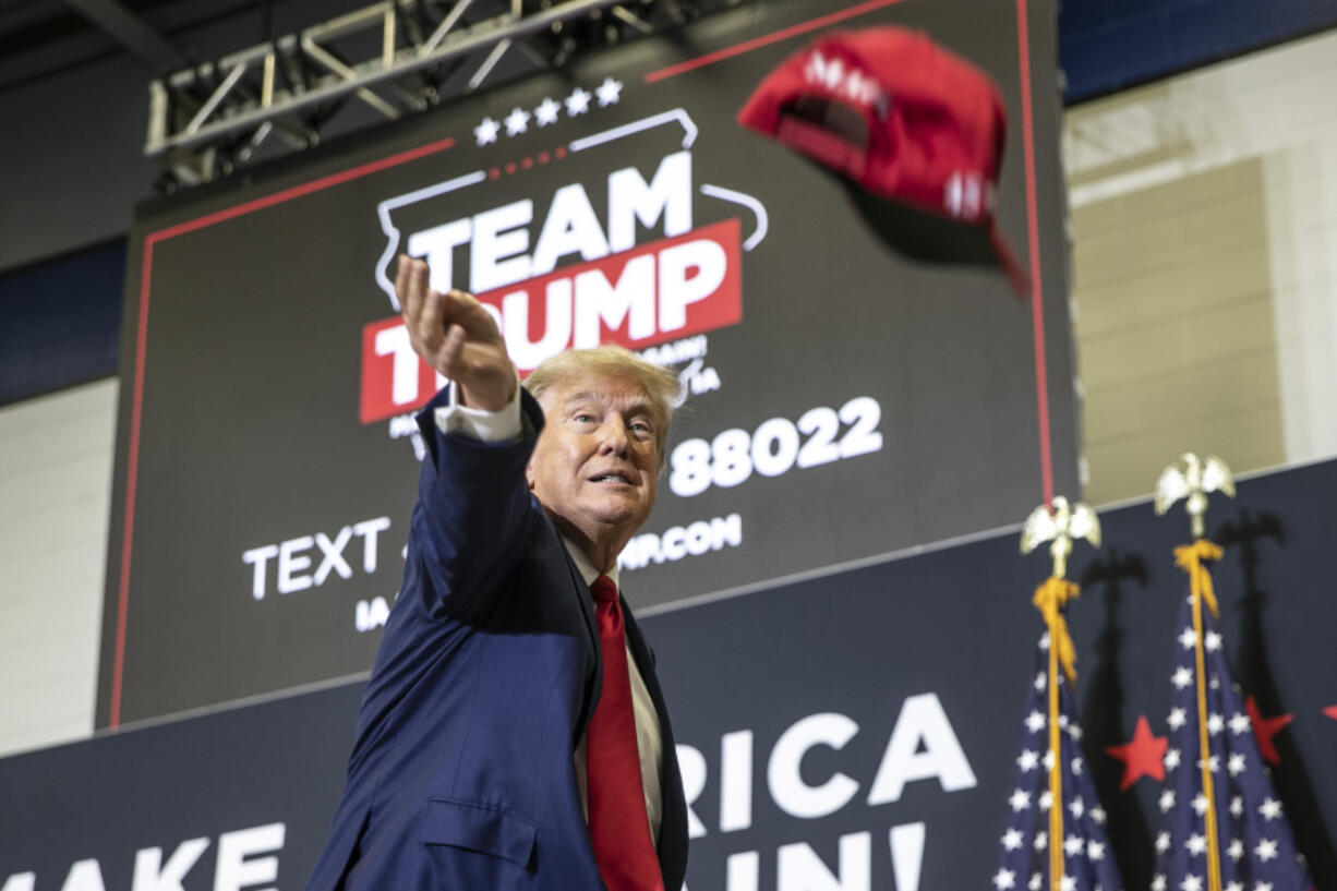 Republican presidential candidate and former President Donald Trump tosses out hats to the crowd during a caucus event, Saturday, Dec. 2, 2023, at Kirkwood Community College in Cedar Rapids, Iowa.