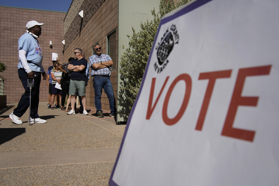 FILE - People wait in line to vote at a polling place on June 14, 2022, in Las Vegas. Six Republicans who have been indicted on charges that they submitted paperwork to Congress falsely declaring Donald Trump the winner of the Western swing state in 2020 are scheduled to make their initial court appearances Monday.