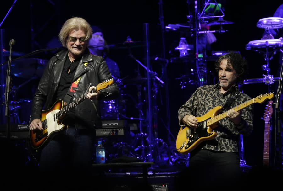 FILE - Daryl Hall, left, and John Oates perform in Glendale, Ariz. on July 17, 2017. After more than a half-century of making music together, Hall is suing Oates over a proposed sale of his share of a Hall &amp; Oates business partnership that Hall says he hasn&rsquo;t approved. A Nashville judge recently paused the sale of Oates&rsquo; stake in Whole Oats Enterprises LLP to Primary Wave IP Investment Management LLC pending arbitration, or until Feb. 17, 2024.