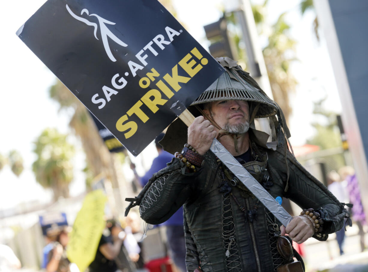 FILE - SAG-AFTRA member Bruce D. Mitchell participates in a post apocalyptic-themed picket line outside Netflix studios, Nov. 8, 2023, in Los Angeles. Hollywood&rsquo;s actors have voted to ratify the deal with studios that ended their strike after nearly four months, leaders announced Tuesday, Dec. 5, 2023.