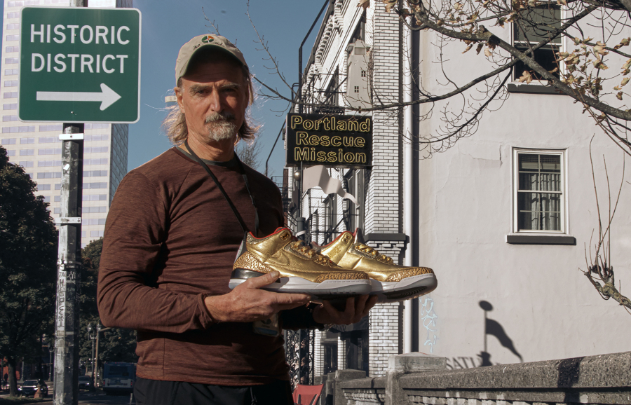 This photo provided by the Portland Rescue Mission shows James Free posing for a photo with a pair of of gold Nike Air Jordan 3 sneakers at the Portland Rescue Mission on Sunday, Oct. 30, 2023, in Portland, Ore.  A pair of rare Nike sneakers donated to a homeless shelter in Portland, Oregon, are up for auction and are expected to raise as much as $20,000. Why? They were custom-made for filmmaker Spike Lee.