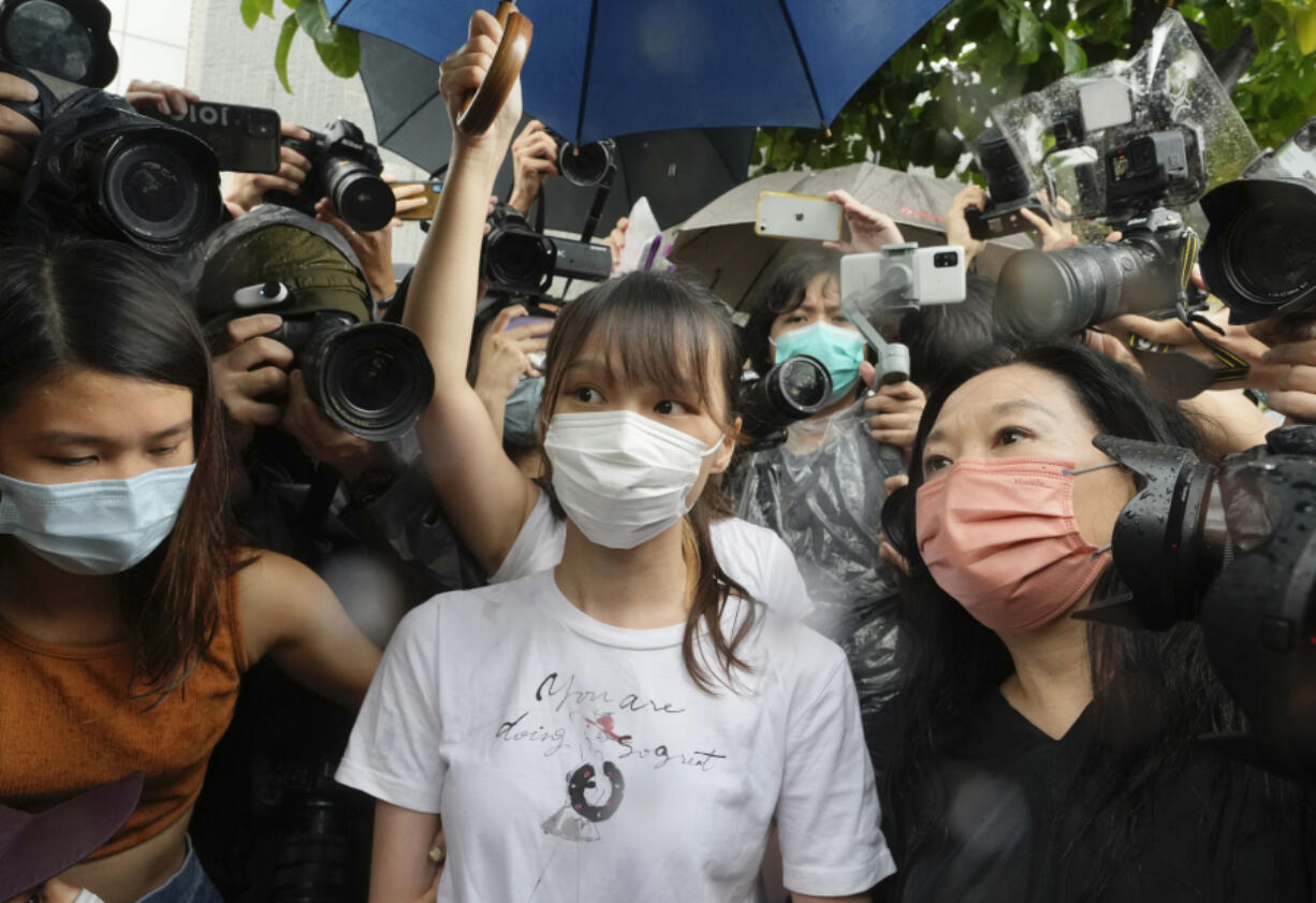 FILE- Agnes Chow, center, a prominent pro-democracy activist who was sentenced to jail for her role in an unauthorized protest, is released in Hong Kong Saturday, June 12, 2021.