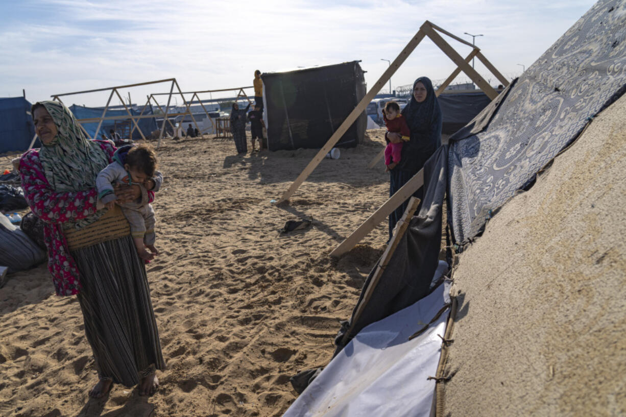 Palestinians displaced by the Israeli bombardment of the Gaza Strip gather at a tent camp, in Rafah, southern Gaza strip, Monday, Dec. 4, 2023. Hundreds of thousands of Palestinians have fled their homes as Israel moves ahead with a ground offensive against the ruling Hamas militant group.