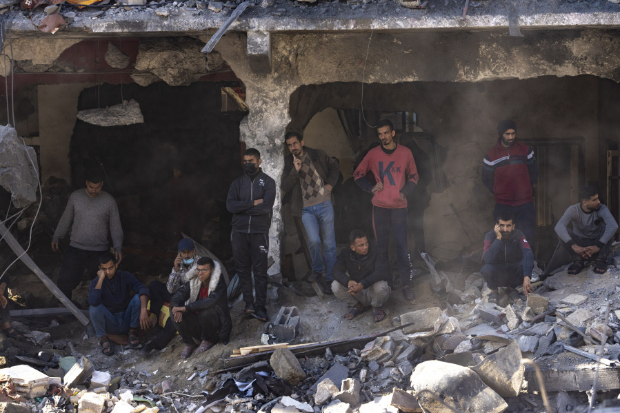 Palestinians search for bodies and survivors in the rubble of a residential building destroyed in an Israeli airstrike, in Rafah, southern Gaza Strip, Tuesday, Dec. 19, 2023.