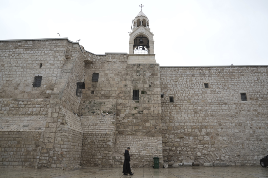 A priest walks by the Church of the Nativity, traditionally believed to be the birthplace of Jesus, on Christmas Eve, in the West Bank city of Bethlehem, Sunday, Dec. 24, 2023. Bethlehem is having a subdued Christmas after officials in Jesus&#039; traditional birthplace decided to forgo celebrations due to the Israel-Hamas war.