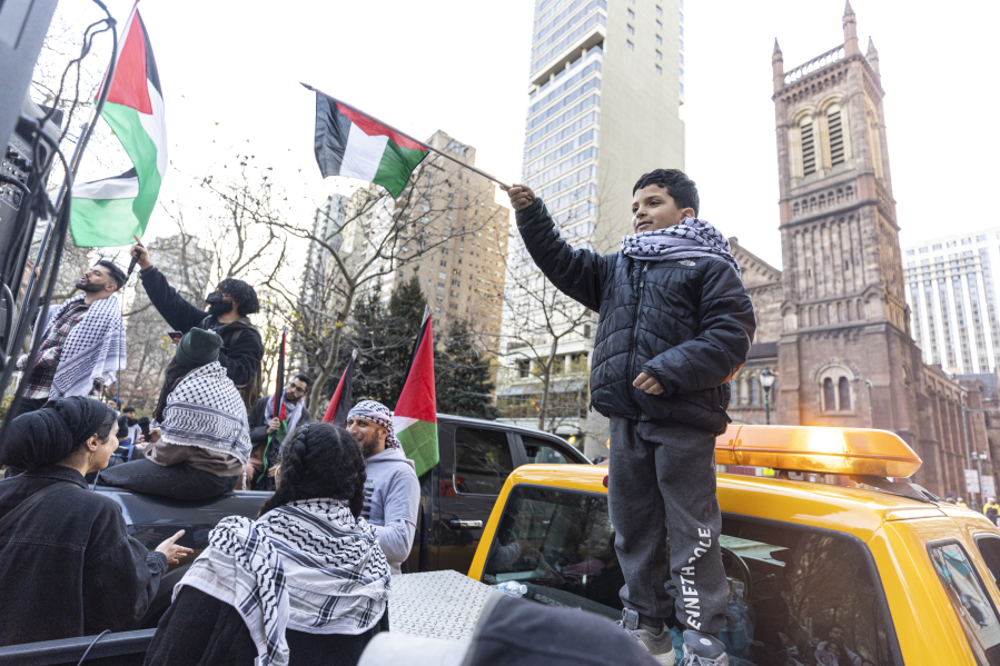 Darweesh Mustafa, 7, of Northeast Philadelphia, Pa., holds a Palestine flag showing his support during a protest outside Rittenhouse Square in Philadelphia, Saturday, Dec. 16 , 2023.
