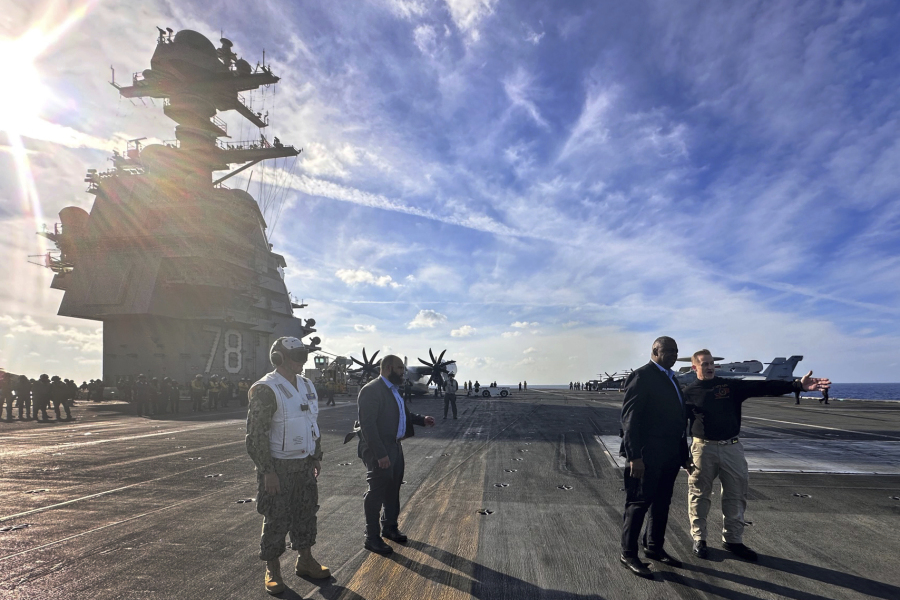 Defense Secretary Lloyd Austin, second right, talks with the commanding officer of the USS Gerald R. Ford, Navy Capt. Rick Burgess, right, during an unannounced visit to the ship on Wednesday, Dec. 20, 2023. The USS Gerald R. Ford has been sailing just a few hundred miles off the coast of Israel to prevent the Israel-Hamas war from expanding into a regional conflict.