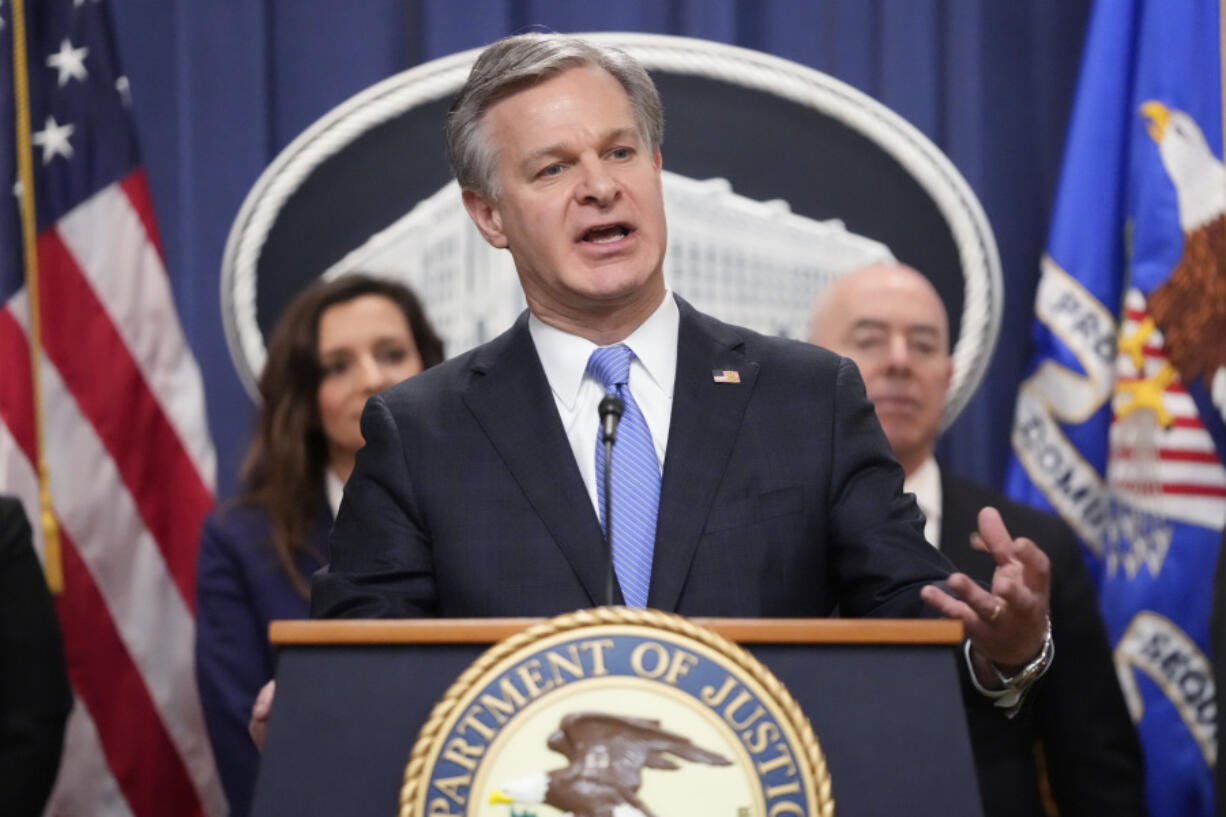 FBI Director Christopher Wray, speaks with reporters during a news conference at the Department of Justice, Wednesday, Dec. 6, 2023, in Washington, as Assistant Attorney General Nicole M. Argentieri of the Criminal Division, left, and Secretary of Homeland Security Alejandro Mayorkas, look on.