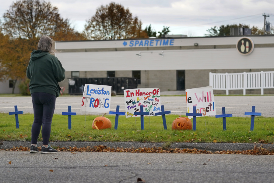 FILE - A woman visits a makeshift memorial outside Sparetime Bowling Alley, the site of one of this week&rsquo;s mass shootings, Saturday, Oct. 28, 2023, in Lewiston, Maine.  Police in Maine feared confronting Robert Card, an Army reservist in the weeks prior to the worst mass shooting in state history would &ldquo;throw a stick of dynamite on a pool of gas,&rdquo; according to footage released by law enforcement, Friday, Dec. 22. (AP Photo/Robert F.