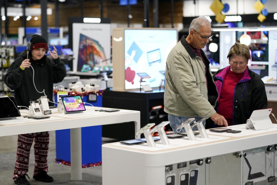 FILE - Bob Adkison, center, and his wife Rosie, right, browse computer tablets at a Best Buy store, Friday, Nov. 24, 2023, in Charlotte, N.C.
