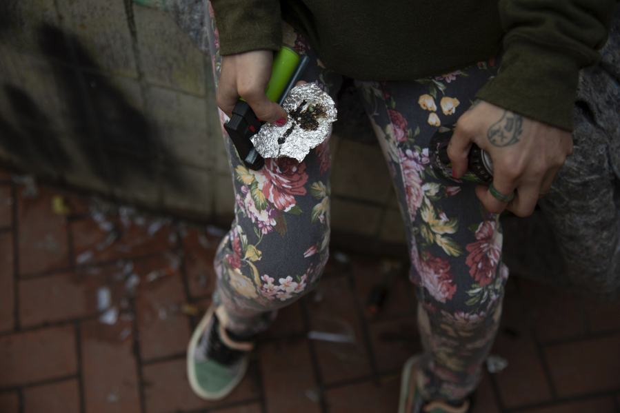 FILE - A person holds drug paraphernalia near the Washington Center building on SW Washington St. in downtown Portland, Ore., where heavy drug use has become common. The fight against fentanyl is increasingly being waged in schools, jails and on city streets in the Pacific Northwest, where state officials in Oregon and Washington have named it a top issue in upcoming legislative sessions amid a sharp increase in overdose deaths.