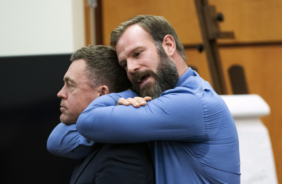 Defendant Matthew Collins, right, demonstrates a lateral vascular neck restraint on his attorney Casey Arbenz during the trial of three Tacoma Police officers in the killing of Manny Ellis, at Pierce County Superior Court, Monday, Dec. 4, 2023, in Tacoma, Wash. Tacoma Police Officers Christopher Burbank, Matthew Collins and Timothy Rankine stand trial for charges related to the March 2020 killing of Ellis.
