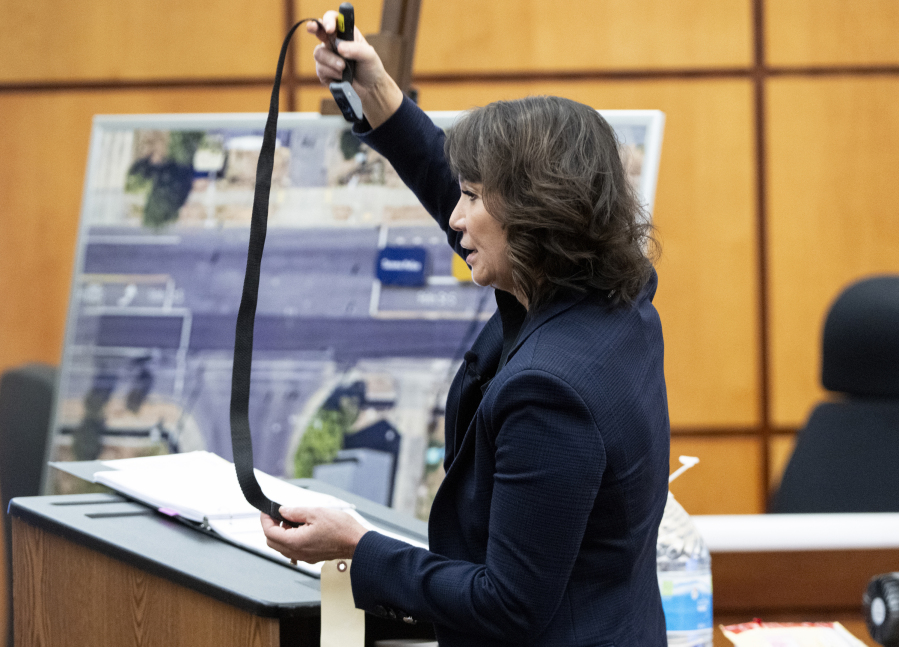 Special Assistant Attorney General Patty Eakes holds up the hobble used on Manny Ellis while giving closing arguments for the state during the trial of three Tacoma Police officers in the killing of Ellis, at Pierce County Superior Court, Tuesday, Dec. 12, 2023, in Tacoma, Wash. Tacoma Police Officers Christopher Burbank, Matthew Collins and Timothy Rankine stand trial for charges related to the March 2020 killing of Ellis.