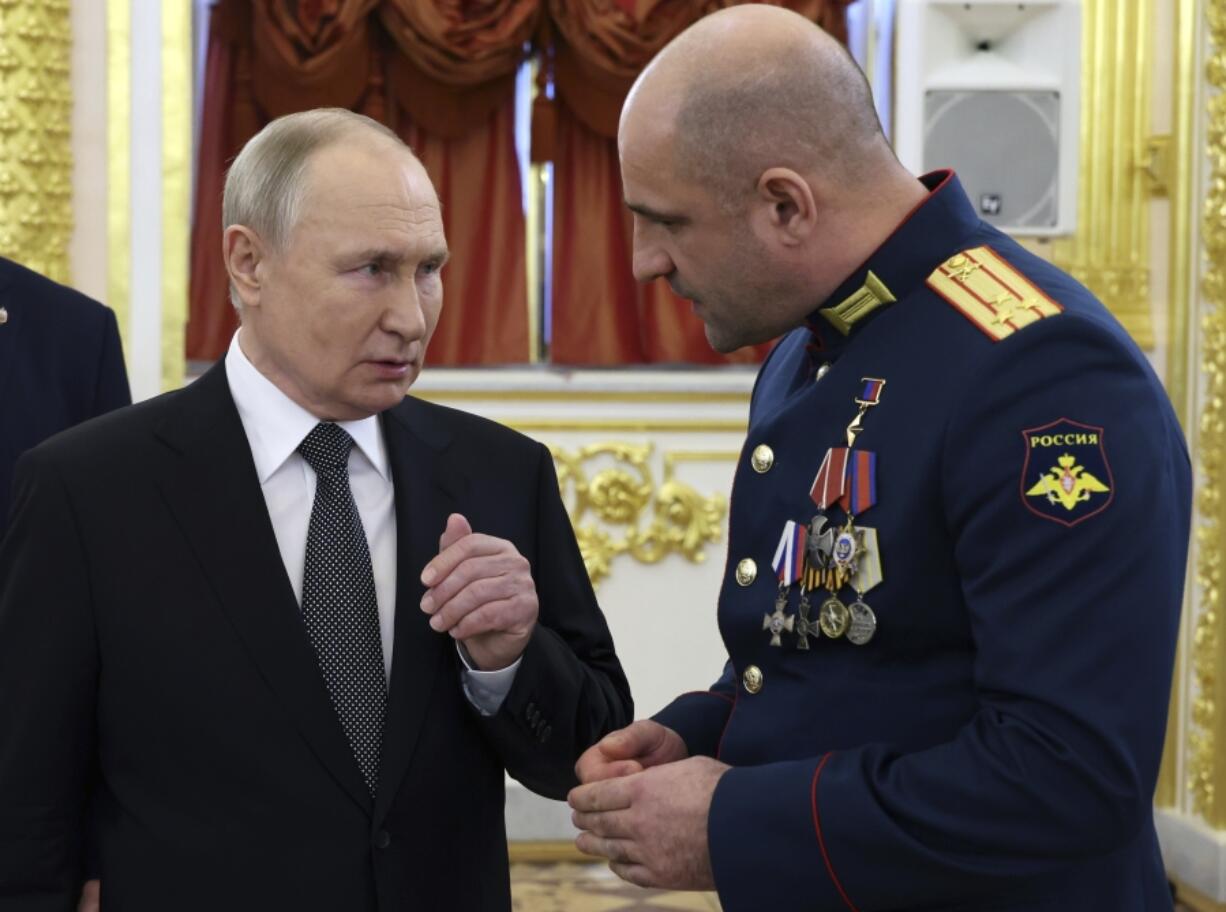 Russian President Vladimir Putin, left, speaks to commander of the reconnaissance battalion &ldquo;Sparta&rdquo; Artem Zhoga after a ceremony to present Gold Star medals to Heroes of Russia on the eve of Heroes of the Fatherland Day at the St. George Hall of the Grand Kremlin Palace, in Moscow, Russia, Friday, Dec. 8, 2023.